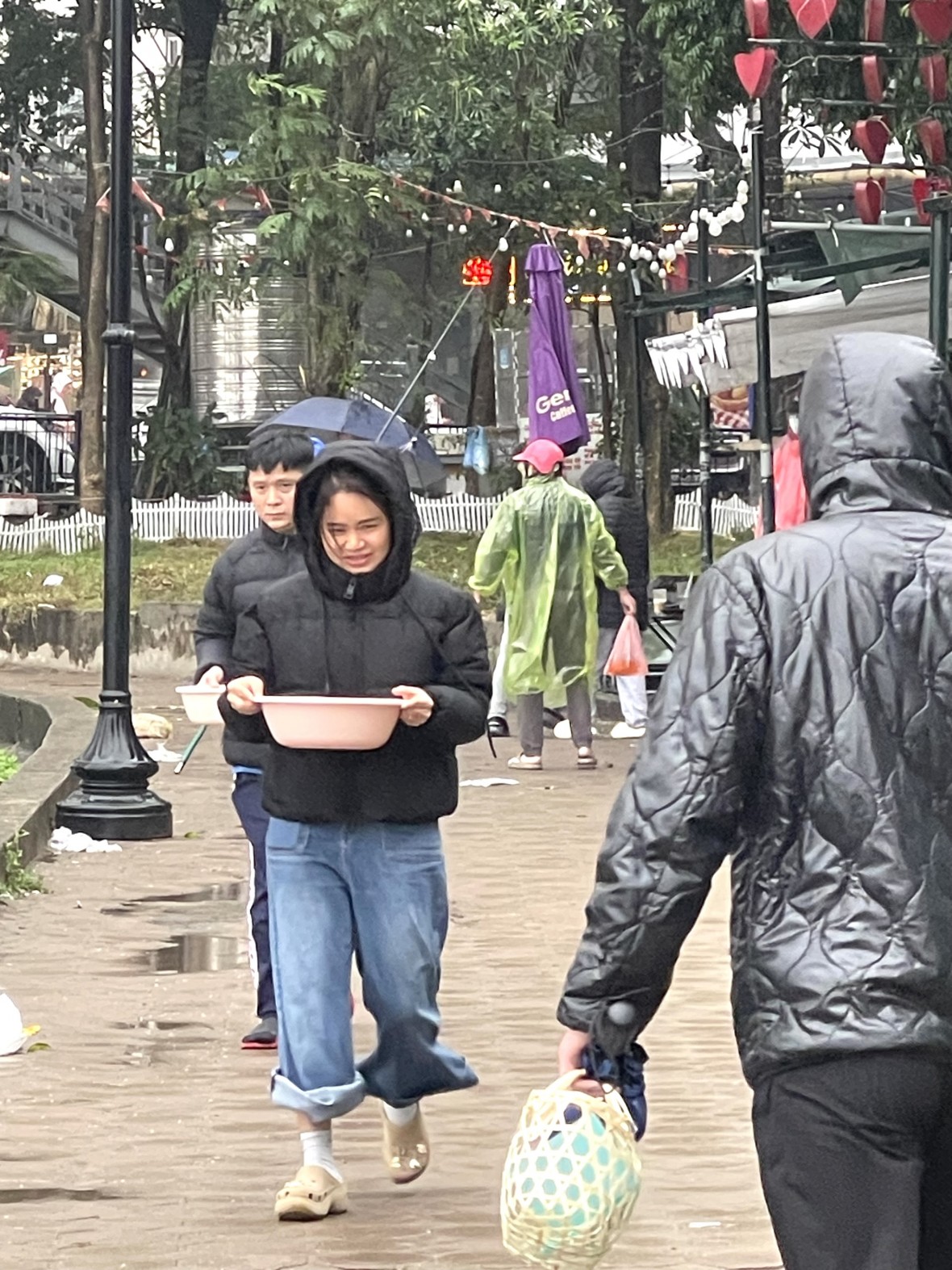 Người Hà Nội mặc áo mưa thả cá chép sớm trong ngày mưa lạnh Người Hà Nội mặc áo mưa thả cá chép sớm trong ngày mưa lạnh