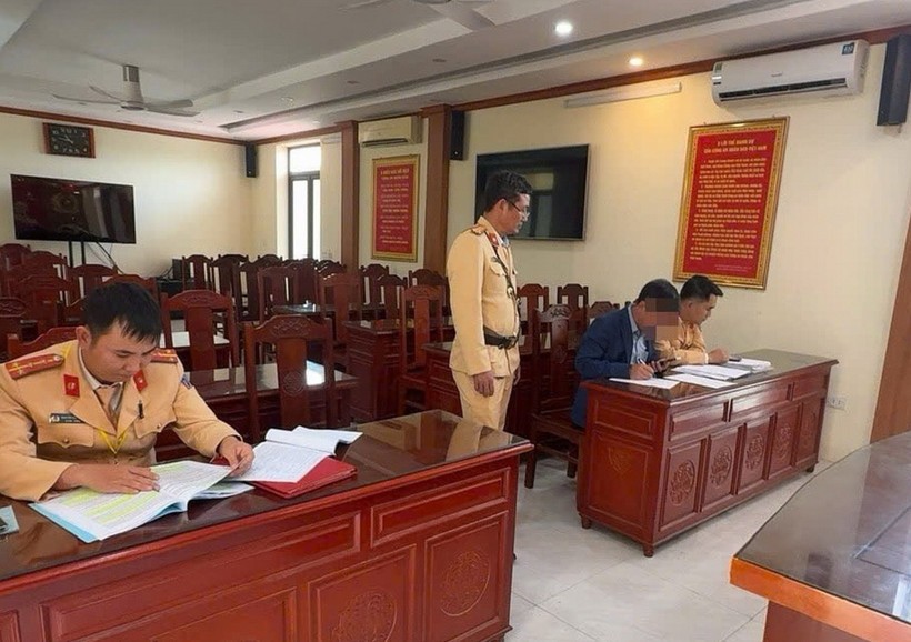 Lực lượng chức năng làm việc với người vi phạm. (Ảnh: TTXVN)