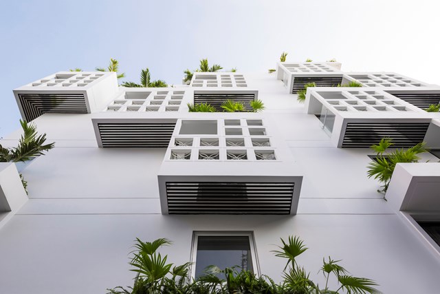 Mặt tiền của ng&ocirc;i nh&agrave; được thiết kế kết hợp 2 lớp. Lớp trong l&agrave; tường gạch c&ugrave;ng &ocirc; cửa k&iacute;nh, lớp ngo&agrave;i l&agrave; gạch rỗng tạo th&agrave;nh c&aacute;c khối vu&ocirc;ng bao bọc ban c&ocirc;ng.