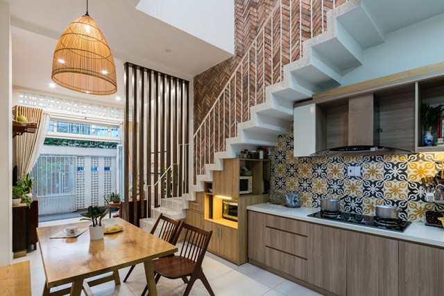 Chiều ngang của ng&ocirc;i nh&agrave; kh&aacute; hạn chế n&ecirc;n c&aacute;c kiến tr&uacute;c sư đ&atilde; thiết kế bếp dưới gầm cầu thang, b&agrave;n ăn được đặt thẳng dưới giếng trời để tối đa h&oacute;a &aacute;nh s&aacute;ng v&agrave; lưu th&ocirc;ng gi&oacute; qua b&ecirc;n trong.&nbsp; &nbsp;