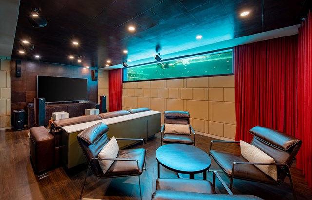 Tầng 1 l&agrave; kh&ocirc;ng gian giải tr&iacute; của biệt thự với một phần k&iacute;nh nh&igrave;n ra bể bơi v&ocirc; cực ở ph&iacute;a tr&ecirc;n, tạo cảm gi&aacute;c kh&ocirc;ng gian dưới mặt nước.&nbsp;