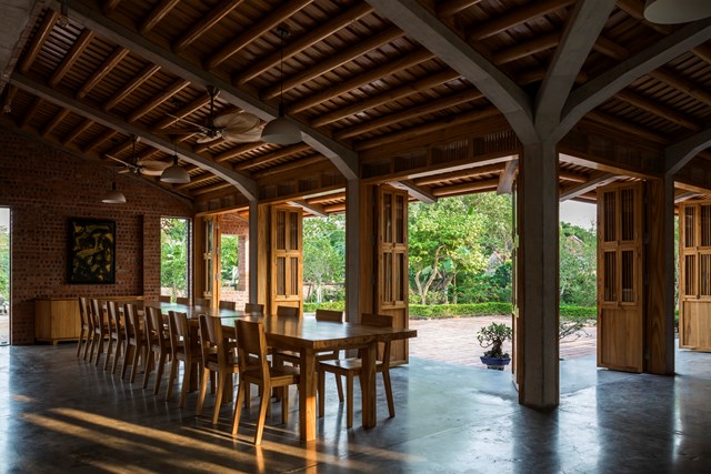 Tại tầng 1, kh&ocirc;ng gian b&agrave;n thờ v&agrave; ph&ograve;ng ăn - sinh hoạt li&ecirc;n kết với nhau v&agrave; th&ocirc;ng ra s&acirc;n trung t&acirc;m ph&iacute;a trước để mọi người c&oacute; thể linh hoạt di chuyển. C&aacute;c tiện &iacute;ch như nh&agrave; bếp, khu để đồ v&agrave; hai ph&ograve;ng ngủ ch&iacute;nh được bố tr&iacute; ở mặt sau của ng&ocirc;i nh&agrave;. 3 ph&ograve;ng kh&aacute;ch được đặt ở tầng thứ hai, nơi người ở c&oacute; thể nh&igrave;n ra thảm thực vật tươi tốt xung quanh.