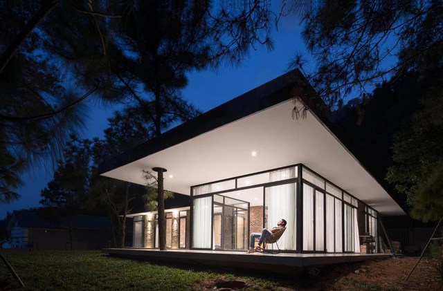 Nằm tr&ecirc;n đồi cao, thay v&igrave; san lấp mặt bằng để mở rộng diện t&iacute;ch x&acirc;y dựng, c&aacute;c kiến tr&uacute;c sư đ&atilde; coi trọng&nbsp;yếu tố địa h&igrave;nh, giữ lại tầm nh&igrave;n rộng tạo ra lợi thế tuyệt vời cho ngoi&nbsp;nh&agrave;. V&igrave; vậy khu đất được chia l&agrave;m 2 phần, khu ph&iacute;a dưới l&agrave;m gara, ph&ograve;ng phụ v&agrave; một&nbsp;con đường ngoằn ngo&egrave;o dẫn đến khu vực cao hơn - nơi c&oacute; ng&ocirc;i nh&agrave; trong suốt,&nbsp;ph&ograve;ng kh&aacute;ch tho&aacute;t ra khỏi sườn đồi tạo ra 3 mặt tầm nh&igrave;n xuống thung lũng v&agrave; nhận được&nbsp;&aacute;nh nắng xuy&ecirc;n qua những t&aacute;n c&acirc;y.