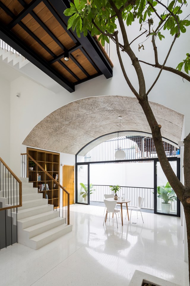 To&agrave;n bộ ph&ograve;ng kh&aacute;ch v&agrave; khu vực bếp nằm ở kh&ocirc;ng gian v&ograve;m thứ 2 tại tầng 1. Đ&acirc;y l&agrave; khu vực nằm giữa kh&ocirc;ng gian v&ograve;m thứ nhất v&agrave; thứ ba n&ecirc;n chỉ cần mở cửa, cả ba kh&ocirc;ng gian sẽ kết nối với nhau.