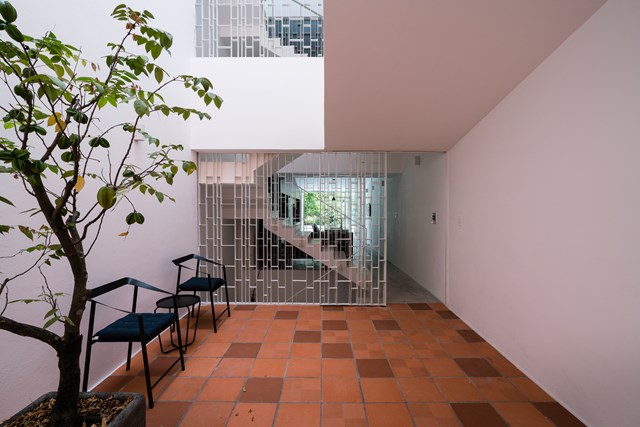 V&igrave; hệ thống cầu thang h&igrave;nh chữ U l&agrave;m giảm &aacute;nh s&aacute;ng chiếu thẳng đứng v&agrave;o nh&agrave; n&ecirc;n kiến tr&uacute;c sư đ&atilde; tạo ra một khoảng trống chiếu s&aacute;ng tự nhi&ecirc;n ở ph&iacute;a sau ng&ocirc;i nh&agrave;. Khoảng trống n&agrave;y mang lại &aacute;nh s&aacute;ng thẳng đứng cho một khu vườn nhỏ tr&ecirc;n tầng hai.