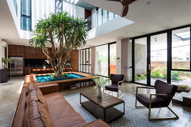 Ở tầng trệt, s&acirc;n trong mang lại đủ &aacute;nh s&aacute;ng cho bồn trồng trung t&acirc;m với một c&acirc;y nhiệt đới, trọng t&acirc;m ch&iacute;nh của kh&ocirc;ng gian gi&uacute;p ph&acirc;n chia bếp v&agrave; ph&ograve;ng ăn với ph&ograve;ng kh&aacute;ch.