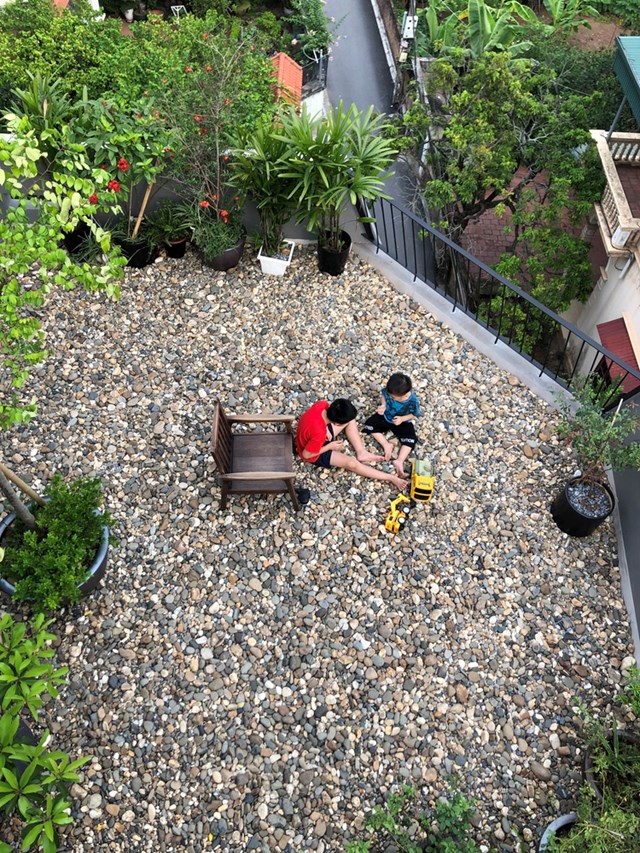 Để hạn chế c&aacute;c con tiếp x&uacute;c nhiều với TV, iPad, gia chủ đ&atilde; nhờ đội kiến tr&uacute;c sư tạo th&ecirc;m nhiều kh&ocirc;ng gian xanh ở tầng thượng, vừa gi&uacute;p con c&oacute; kh&ocirc;ng gian chơi, vừa kh&aacute;m ph&aacute; thi&ecirc;n nhi&ecirc;n, chăm s&oacute;c c&acirc;y vườn... Mảng s&acirc;n thượng với lớp phủ đ&aacute; cuội tự nhi&ecirc;n d&agrave;y 20cm kh&ocirc;ng chỉ gia tăng sự độc đ&aacute;o m&agrave; c&ograve;n l&agrave;m tốt nhiệm vụ giảm nhiệt cho ng&ocirc;i nh&agrave;, đặc biệt trong những ng&agrave;y h&egrave; oi bức.