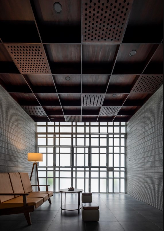 Ng&ocirc;i nh&agrave; nằm gần mặt đường thường xuy&ecirc;n bị ảnh hưởng bởi tiếng ồn giao th&ocirc;ng. Vậy n&ecirc;n, c&aacute;c bức tường b&ecirc;n trong nh&agrave; được sử dụng vật liệu ho&agrave;n thiện c&oacute; bề mặt nh&aacute;m, đồng thời trần nh&agrave; được thiết kế l&agrave; hệ khung rỗng nhưng d&agrave;y, vừa mang lại hiệu quả thẩm mỹ vừa c&oacute; t&aacute;c dụng hấp thụ tiếng ồn.