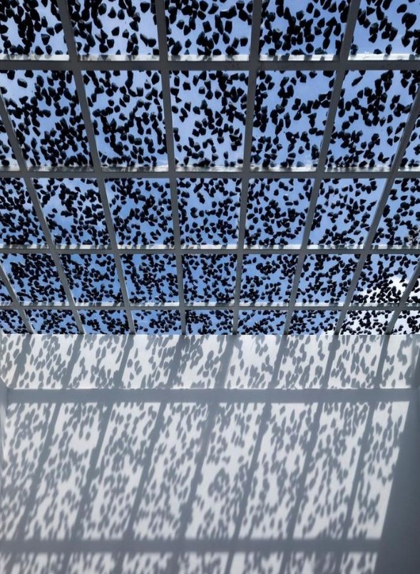 Giải ph&aacute;p rải đ&aacute; ph&iacute;a tr&ecirc;n k&iacute;nh c&ograve;n c&oacute; t&aacute;c dụng điều tiết &aacute;nh s&aacute;ng, tạo b&oacute;ng r&acirc;m. Nhờ đ&oacute;, kh&ocirc;ng gian trong nh&agrave; lu&ocirc;n tr&agrave;n ngập &aacute;nh s&aacute;ng tự nhi&ecirc;n nhưng kh&ocirc;ng hề n&oacute;ng bức.&nbsp;Th&ecirc;m v&agrave;o đ&oacute;, b&oacute;ng từ c&aacute;c lớp đ&aacute; tạo hiệu ứng như &aacute;nh nắng xuy&ecirc;n qua kẽ l&aacute; chiếu xuống ng&ocirc;i nh&agrave;, gi&uacute;p cho kh&ocirc;ng gian nh&agrave; phố gần gũi với thi&ecirc;n nhi&ecirc;n hơn.