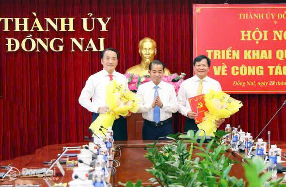 Trao quyết định và tặng hoa cho hai cán bộ.
