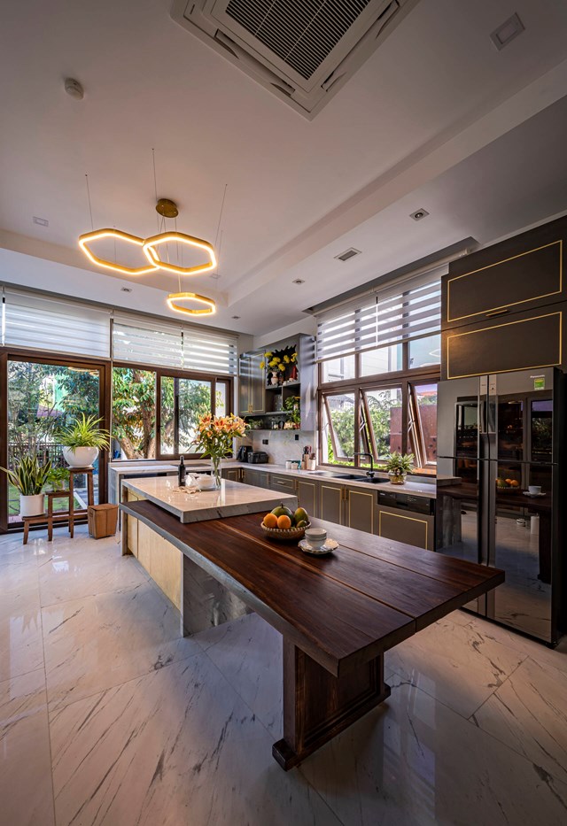 Không gian bếp sử dụng nhiều cửa kính tạo sự kết nối với không gian bên ngoài. Tông màu trầm đem lại cảm giác ấm cúng nhưng không kém phần hiện đại, sang trọng.  