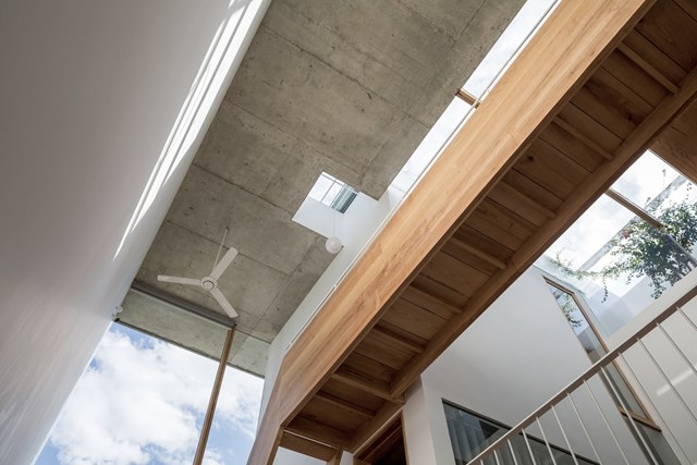 Gỗ l&agrave; vật liệu nội thất ch&iacute;nh tạo n&ecirc;n kh&ocirc;ng gian ấm c&uacute;ng, th&acirc;n thuộc, kết hợp chất liệu b&ecirc; t&ocirc;ng th&ocirc; từ trần nh&agrave; v&agrave; s&agrave;n đ&aacute; đen. B&ecirc;n cạnh đ&oacute;, việc trồng xen kẽ c&acirc;y xanh v&agrave; th&ecirc;m c&aacute;c khu s&acirc;n vườn trong nh&agrave; c&oacute; thể gi&uacute;p tăng sự tương t&aacute;c giữa con người v&agrave; thi&ecirc;n nhi&ecirc;n. &nbsp;