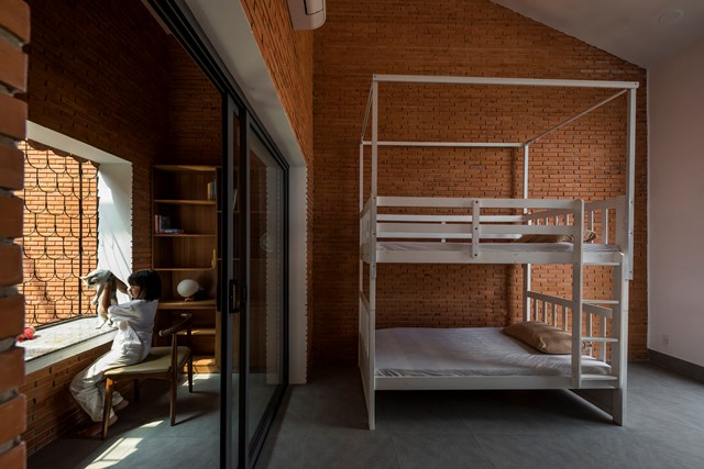 M&aacute;i hi&ecirc;n được hạ thấp, bao bọc lấy kh&ocirc;ng gian học tập của 2 b&eacute;, tạo n&ecirc;n một kh&ocirc;ng gian vừa c&oacute; cảm gi&aacute;c ấm &aacute;p, an to&agrave;n m&agrave; vẫn tho&aacute;ng m&aacute;t. &nbsp;