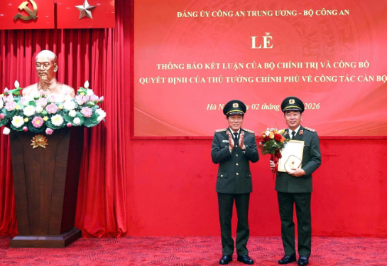 Thừa ủy quyền, Bộ trưởng Lương Tam Quang trao quyết định và tặng hoa chúc mừng Thượng tướng Trần Quốc Tỏ (Ảnh: Bộ Công an).