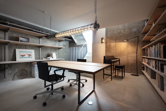 Ph&ograve;ng l&agrave;m việc kết hợp đọc s&aacute;ch được bố tr&iacute; thấp hơn so với mặt đường với hệ thống đ&egrave;n v&agrave;ng ấm c&uacute;ng.