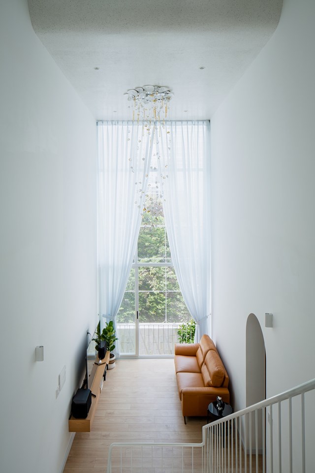 Chất liệu chủ đạo l&agrave; đ&aacute; m&agrave;i kết hợp với hiệu ứng &aacute;nh s&aacute;ng từ những &ocirc; cửa lớn đ&atilde; tạo n&ecirc;n một kh&ocirc;ng gian sống m&agrave;u trắng, nhẹ nh&agrave;ng v&agrave; ấm c&uacute;ng. Điều n&agrave;y đ&atilde; tạo n&ecirc;n n&eacute;t đặc biệt cho c&ocirc;ng tr&igrave;nh ở khu phố v&agrave;o cả ban ng&agrave;y v&agrave; ban đ&ecirc;m.