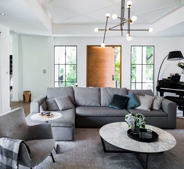 Sofa lớn k&egrave;m với tấm thảm c&ugrave;ng t&ocirc;ng chiếm phần lớn diện t&iacute;ch ph&ograve;ng kh&aacute;ch.