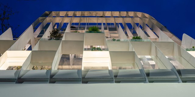 Hệ lam dọc ở mặt tiền của ng&ocirc;i nh&agrave; kh&ocirc;ng chỉ l&agrave;m giảm bức xạ nhiệt m&agrave; c&ograve;n tạo ra hiệu ứng &aacute;nh s&aacute;ng v&agrave; h&igrave;nh học nổi bật giữa khu phố.