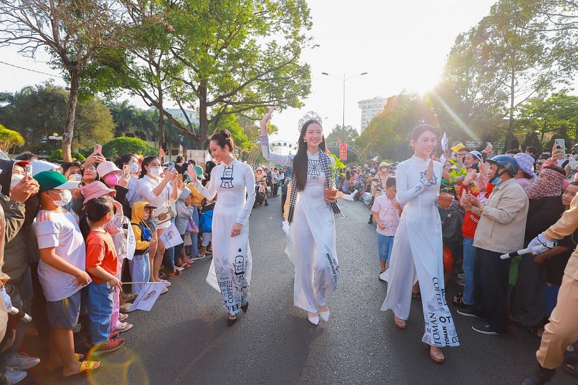 Hoa hậu Tiểu Vy, Hoa hậu Liên lục địa Bảo Ngọc, Á hậu Hoàng My duyên dáng trong bộ áo dài trắng tinh khôi với chủ đề 3 nền văn minh thế giới: Ottoman – Roman – Thiền đang trao tặng sách và cây mầm cà phê đến du khách và người dân tham dự Lễ hội đường phố