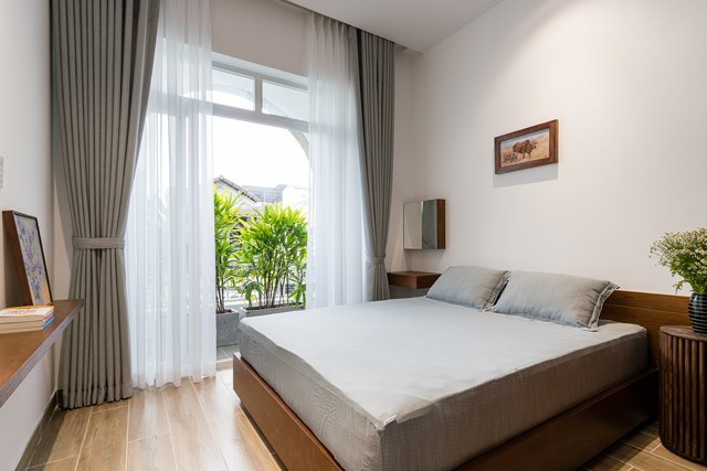 Ph&ograve;ng ngủ với ban c&ocirc;ng tho&aacute;ng rộng, lấy &aacute;nh s&aacute;ng tự nhi&ecirc;n tối đa. Cũng như nhiều khu vực kh&aacute;c trong nh&agrave;, c&aacute;c chậu c&acirc;y được bố tr&iacute; ngo&agrave;i ban c&ocirc;ng gi&uacute;p căn ph&ograve;ng trở n&ecirc;n gần gũi hơn với thi&ecirc;n nhi&ecirc;n, đồng thời hạn chế tầm nh&igrave;n từ ngo&agrave;i v&agrave;o trong ph&ograve;ng.