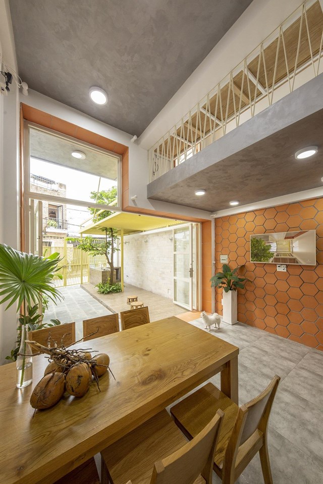 Phòng khách ở tầng trệt sử dụng cửa kính lớn ngăn cách với khoảng sân phía trước. Nếu cần thiết có thể mở hết tầm để phục vụ việc bán hàng. Cuối tầng trệt là phòng ngủ nhỏ dành cho mẹ chủ nhà khi bà ghé thăm. 