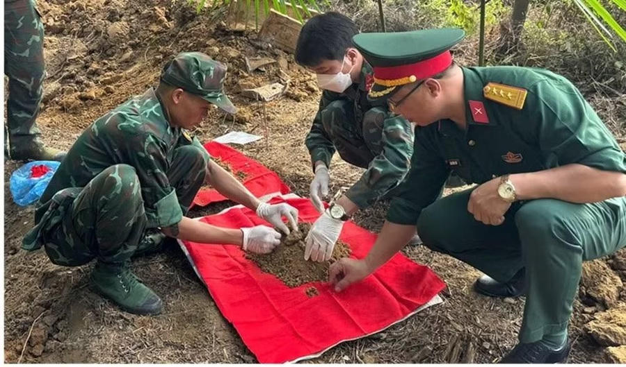 Lực lượng chức năng tiến hành khai quật, cất bốc các hài cốt liệt sĩ. (Ảnh: T. Sơn).