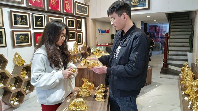 Kh&aacute;ch xem tượng tr&acirc;u v&agrave;ng tại cửa h&agrave;ng.