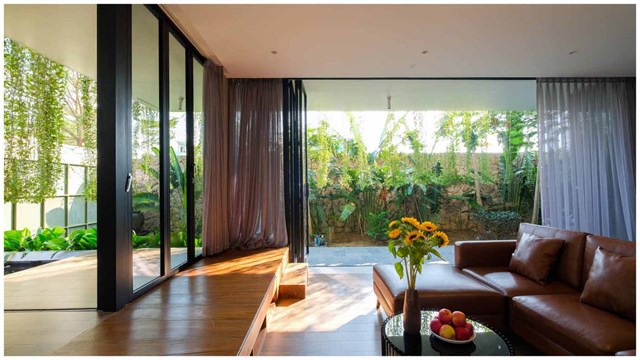 Cửa ph&ograve;ng kh&aacute;ch được thiết kế chạm trần, mở ra khoảng kh&ocirc;ng rộng lớn để đ&oacute;n &aacute;nh s&aacute;ng tối đa, kết nối con người với thi&ecirc;n nhi&ecirc;n.&nbsp;