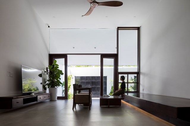 Cửa k&iacute;nh lớn s&aacute;t trần tại ph&ograve;ng kh&aacute;ch x&oacute;a nh&ograve;a ranh giới trong v&agrave; ngo&agrave;i của căn ph&ograve;ng, tăng cảm gi&aacute;c rộng r&atilde;i v&agrave; th&ocirc;ng tho&aacute;ng.