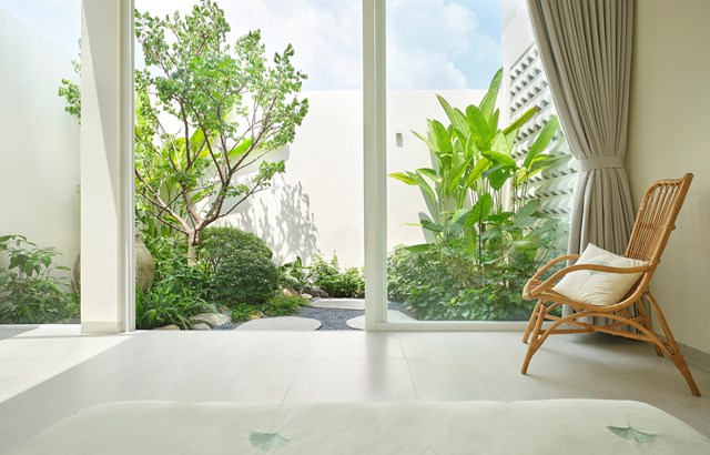 Một phần diện t&iacute;ch cuối nh&agrave; được d&ugrave;ng để l&agrave;m s&acirc;n sau. Vườn c&acirc;y xanh trong s&acirc;n được kết nối với ph&ograve;ng ngủ qua lớp cửa k&iacute;nh. Gia chủ c&oacute; thể tận hưởng sự thanh b&igrave;nh th&ocirc;ng qua những t&aacute;n c&acirc;y xanh m&aacute;t v&agrave; &aacute;nh s&aacute;ng tự nhi&ecirc;n tr&agrave;n ngập trong kh&ocirc;ng gian.