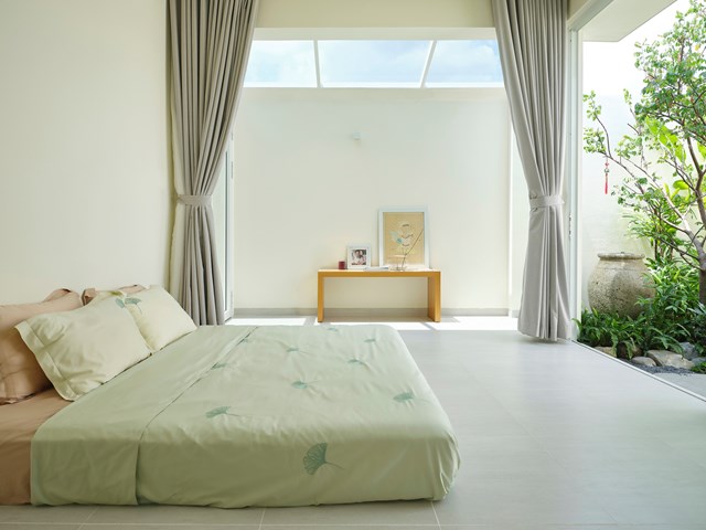 Ph&ograve;ng ngủ thiết kế&nbsp; tối giản với trọng t&acirc;m l&agrave; vẻ đẹp của thi&ecirc;n nhi&ecirc;n. Từ nơi nghỉ ngơi, gia chủ c&oacute; thể ngắm nh&igrave;n bầu trời y&ecirc;n b&igrave;nh qua m&aacute;i k&iacute;nh ngo&agrave;i h&agrave;nh lang.