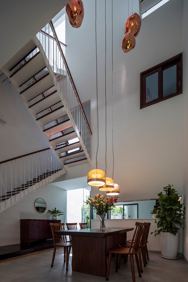 Khu th&ocirc;ng tầng tại vị tr&iacute; b&agrave;n ăn l&agrave; tr&aacute;i tim của ng&ocirc;i nh&agrave;. Khoảng kh&ocirc;ng n&agrave;y l&agrave; nơi kết nối c&aacute;c ph&ograve;ng ngủ ở tầng 2.