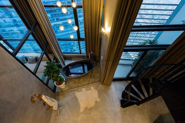 Một cầu thang sắt uốn được thiết kế độc lập b&ecirc;n trong ph&ograve;ng ngủ master để dẫn lối xuống khu vực phụ n&agrave;y.