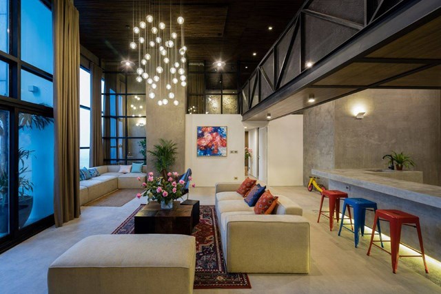 Khu vực b&agrave;n ghế tiếp kh&aacute;ch ở vị tr&iacute; trung t&acirc;m. B&agrave;n gỗ, hệ ghế sofa c&ugrave;ng t&ocirc;ng m&agrave;u trầm mang đến cảm gi&aacute;c ấm c&uacute;ng, gần gũi.