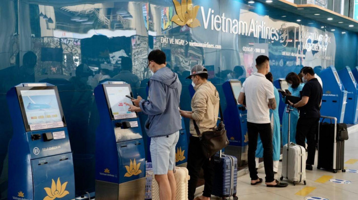 Hành khách làm thủ tục tại kiosk check-in sân bay quốc tế Nội Bài