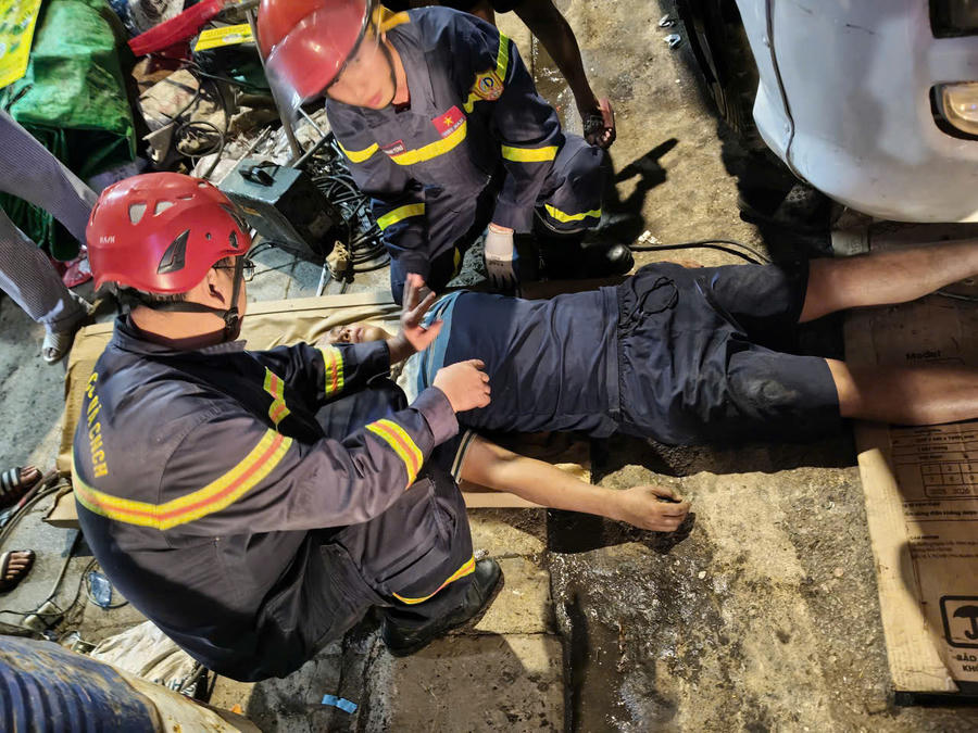 Lực lượng chức năng tiến hành giải cứu người đàn ông bị mắc kẹt. (Ảnh: BCA)