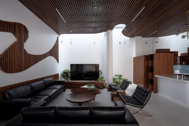 Tầng một l&agrave; kh&ocirc;ng gian của ph&ograve;ng kh&aacute;ch, khu vực ăn, bếp v&agrave; khoảng s&acirc;n vườn trước nh&agrave;. Một trong những điểm nhấn của ph&ograve;ng kh&aacute;ch l&agrave; hệ trần bằng gỗ uốn lượn. Phần gỗ&nbsp;n&agrave;y gi&uacute;p x&oacute;a đi c&aacute;c v&aacute;ch tường th&ocirc; cứng.