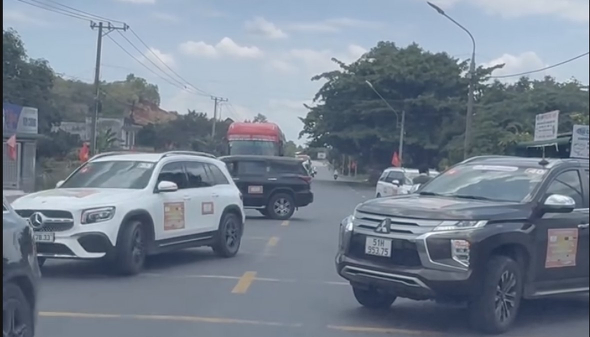 Hai chiếc xe chắn hai chiều quốc lộ 20 đoạn qua huyện Đạ Huoai (tỉnh Lâm Đồng) để xe từ Đại Tùng Lâm Hoa Sen qua đường