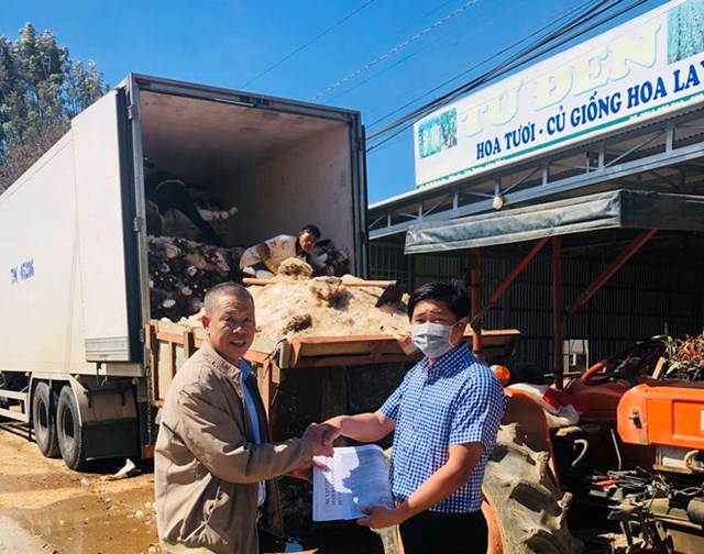 &Ocirc;ng Phan Thanh Sang (phải), Chủ tịch Hiệp hội Hoa L&acirc;m Đồng, trao văn bản của UBND TP HCM cho l&aacute;i xe vận chuyển hoa được ph&eacute;p v&agrave;o nội th&agrave;nh v&agrave; c&aacute;c chợ hoa đầu mối tại TP HCM