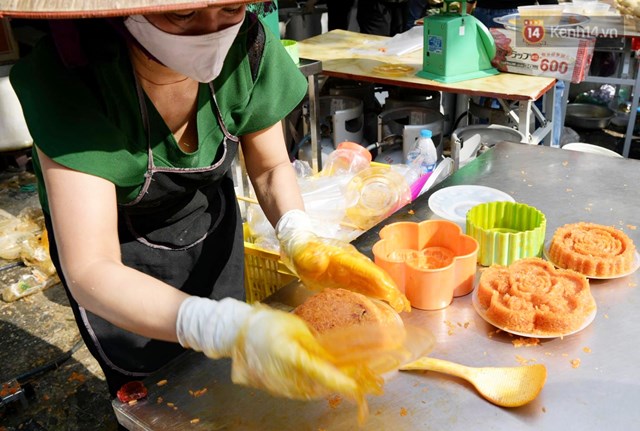 Một nh&acirc;n vi&ecirc;n đ&oacute;ng x&ocirc;i gấc v&agrave;o khu&ocirc;n thoăn thoắt cho kịp trả đơn